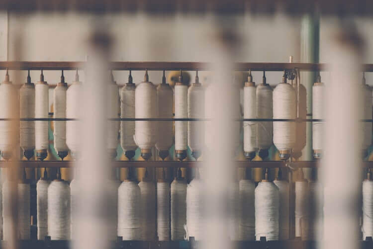 Image showcasing multiple cotton threads cones in a textile factory